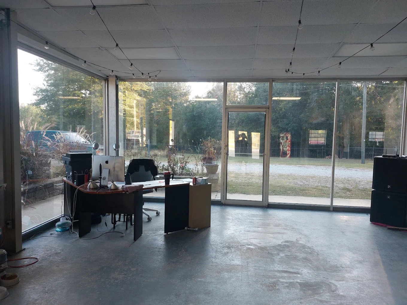 Modern office space with desk setup and large windows overlooking courtyard