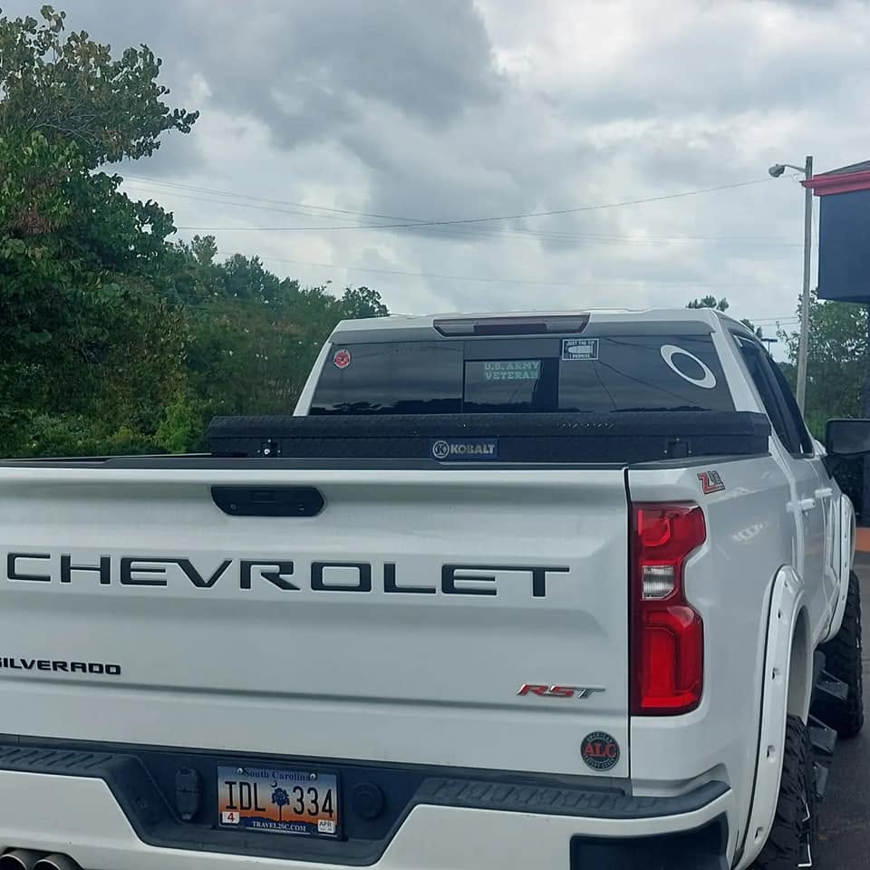 White Chevrolet Silverado RST pickup truck with Kobalt toolbox in parking lot