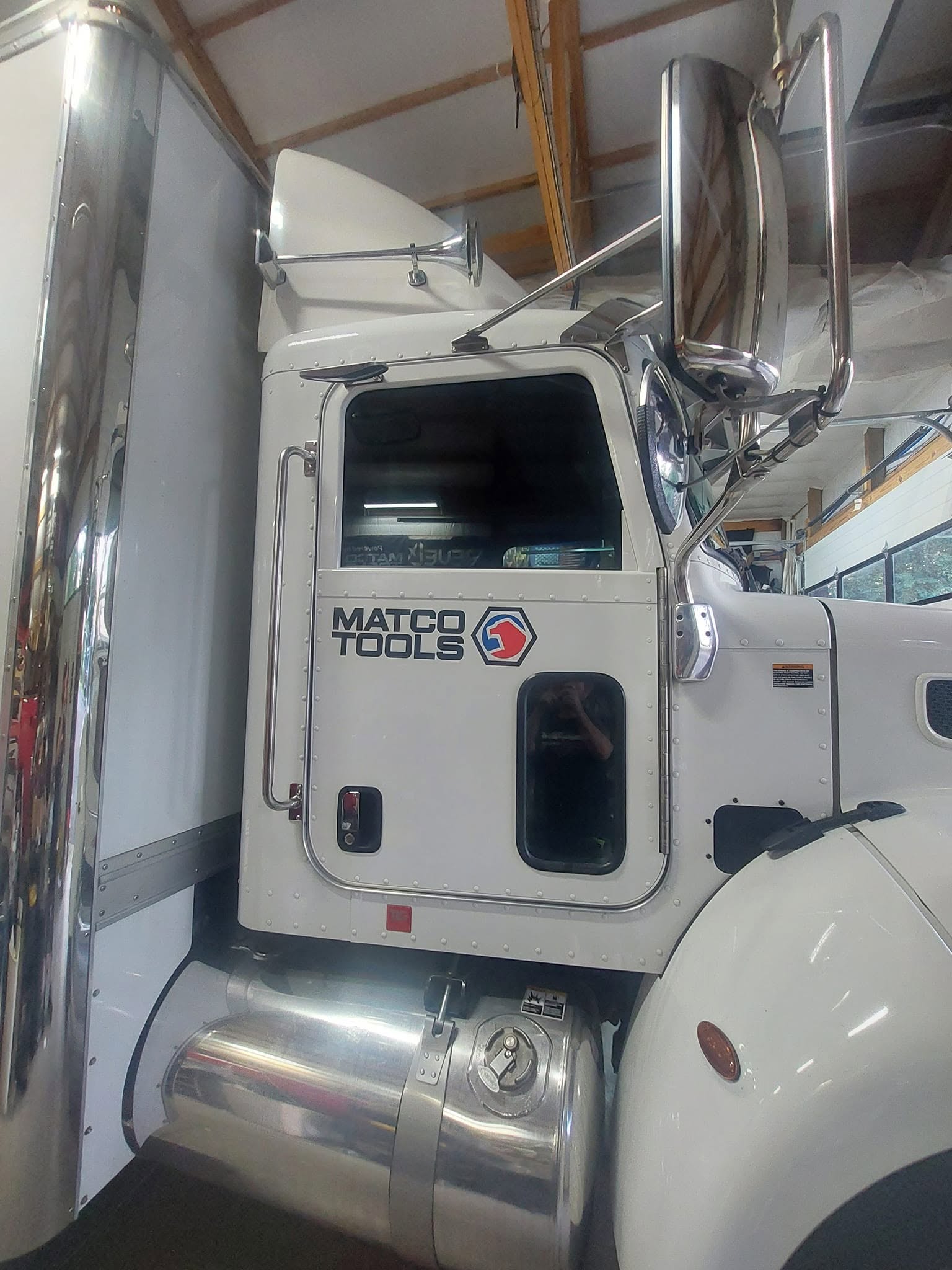 White Matco Tools service truck parked in warehouse with chrome mirrors and fuel tank visible