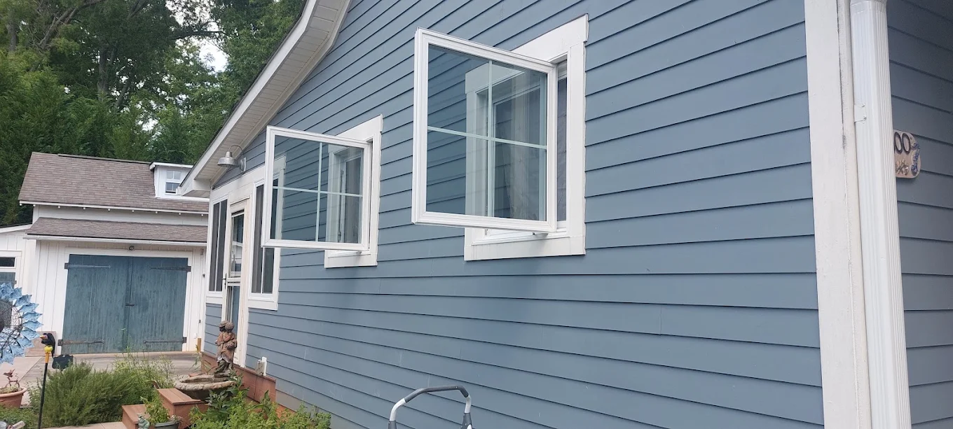 Blue-gray house exterior with white-trimmed windows and horizontal siding